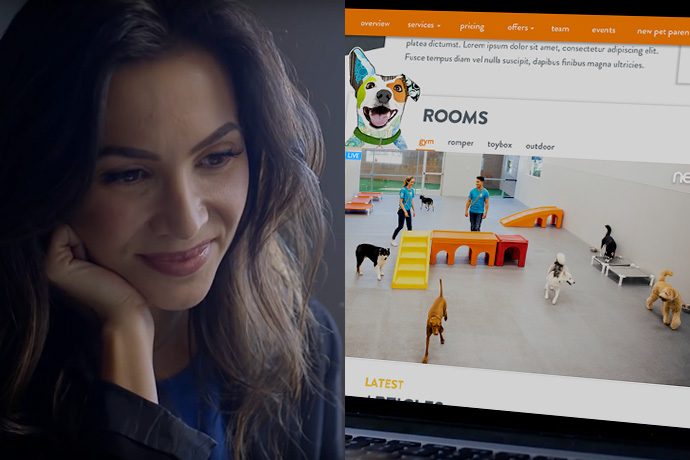 Woman watching dogs playing at Dogtopia of New Orleans daycare through the webcam.