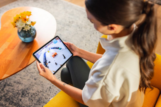 Pet parent watching Dogtopia playroom livestream on tablet